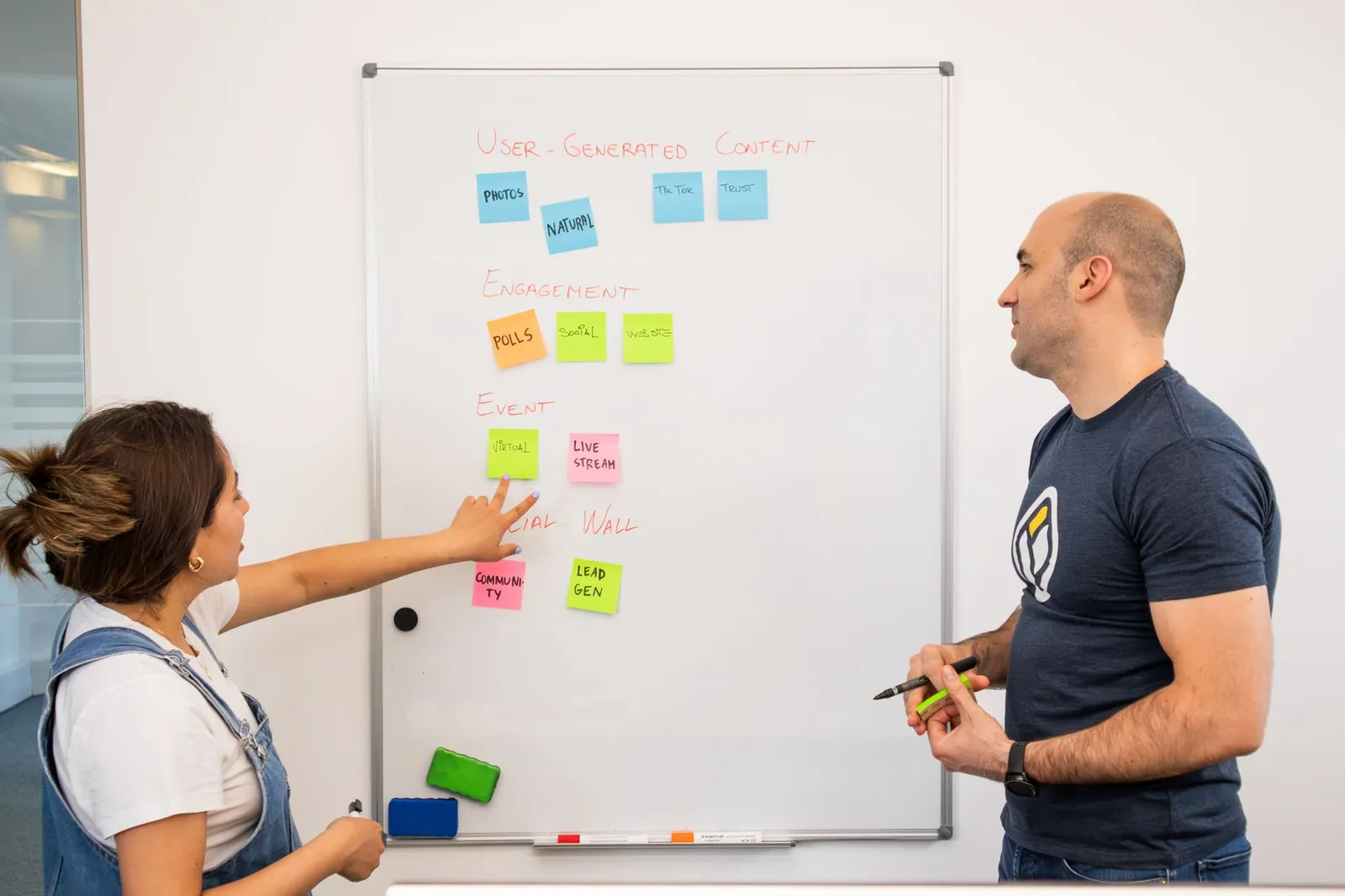 Small design team reviewing interface sketches and sticky notes in a studio